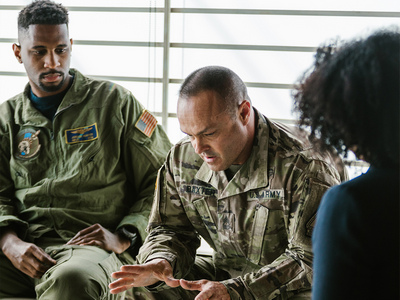 Image of men in military uniforms one male is speaking.